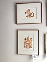 Both framed prints hung on wall