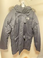 Full view of hooded North Face coat hanging
