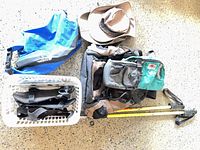 Overall lot layout showing backpack, Tilley hat, dry bag, trekking poles, teal waist pack, grey pouch, basket of straps
