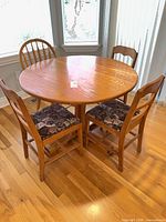 Round oak table with four chairs surrounding
