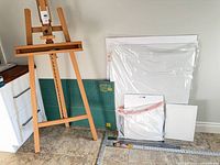 Group shot of easel, cutting mat, canvases, rulers on floor
