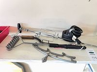 Full view of all items on shelf: spit rod, motor, brushes, grate lifter