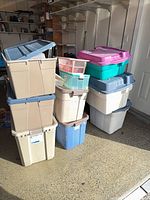 Stack of assorted large plastic totes and smaller clear boxes