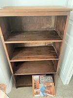 Front view of bookcase with two books on bottom shelf