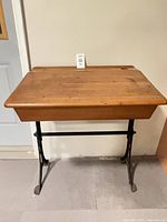 Front view of desk showing wood top and iron base