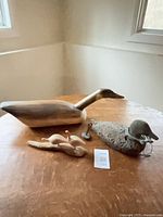 All three goose carvings displayed on tabletop