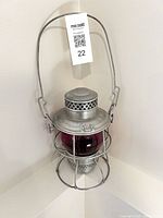 Full view of lantern hanging, showing handle and red globe