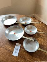 All five copper frying pans nested showing size range and handles