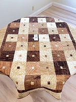 Full view of quilted throw draped over round table