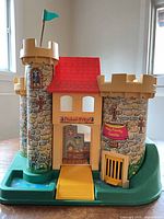 Front view showing turrets, gatehouse, drawbridge, flag