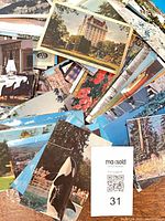 Pile of assorted vintage Canadian postcards spread out, showing orca postcard and hotel scene