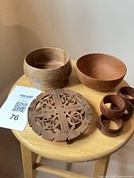 Overall lot: two bowls, four napkin rings, carved trivet