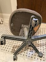 Chair flipped showing underside with pedestal mount, base, and casters