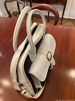 Side view showing thickness, white trim, dual handles, zipper, front pocket flap