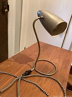Side view of metal desk lamp on wooden surface