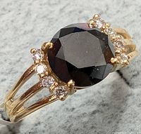 Top view of 10K yellow gold ring with oval black diamond and diamond accents