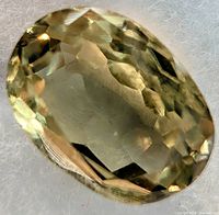 Front view of oval faceted zultanite loose stone on white background