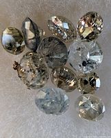 Group of loose diamonds on white pad showing colour variety and inclusions