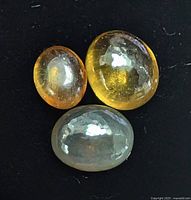 Close-up of three loose cat’s eye chrysoberyl stones on black background