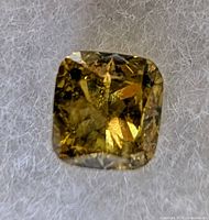 Front view of loose yellow diamond showing cushion cut facets
