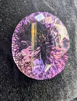 Front view of oval faceted amethyst on dark background