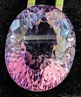 Full view of oval faceted amethyst showing violet hues and laser cut facets