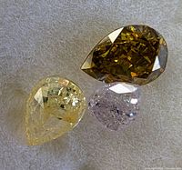 Three pear-cut fancy diamonds on white background