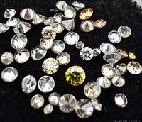 Group of loose round brilliant diamonds on black cloth