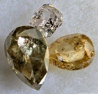 Three loose fancy-colour diamonds on white background