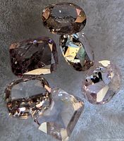 Six loose pink diamonds on fabric background