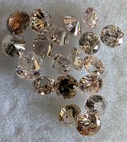 Loose pink round diamonds displayed on fabric surface