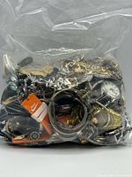 Large clear bag stuffed with mixed costume jewelry and wristwatches