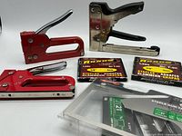 Group shot showing three staple guns, two Arrow T50 staple boxes and sealed pack of JT21 staples