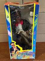 Front view of boxed Jazzman doll showing figure, saxophone and branding