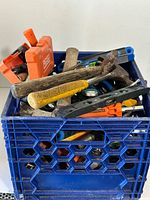 Overall view of blue crate filled with assorted tools