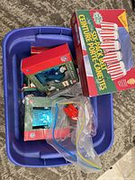 Blue tote with Labatt Blue can hats set, Hallmark green boxes, plastic bags of ornaments