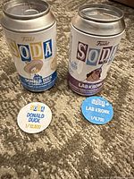 Front view of both Funko Soda cans and pogs