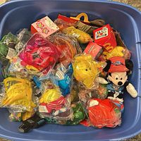 Top view of blue bin filled with sealed Happy Meal toys and Minnie plush