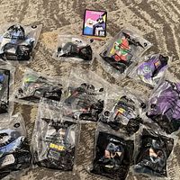 Group view of 14 sealed Batman Happy Meal toys on carpet