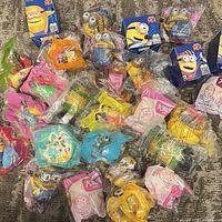 Group shot showing entire assortment of sealed Minions toys, mix of bagged and boxed items