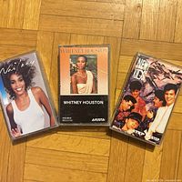 Front view of three cassette albums: Whitney Houston “Whitney”, Whitney Houston self-titled, New Kids on the Block “Step by Step”