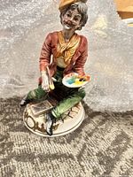 Front view of Capodimonte porcelain painter figurine showing palette and brush