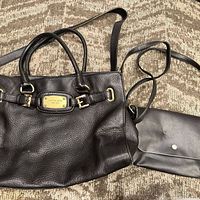 Overall view of Michael Kors handbag and black crossbody