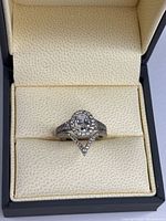 Ring set in box showing oval halo ring stacked with chevron band