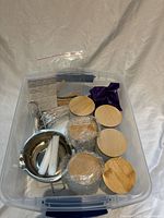 Contents inside tote: frosted jars with bamboo lids, melting pot, wax sticks, wick stickers, stir sticks, purple wax bag
