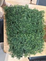 Overview of stacked artificial hedge panels showing foliage texture and lattice backing