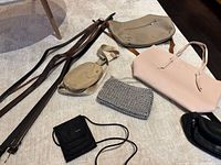 Belts and multiple bags laid out on surface