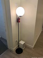 Full lamp showing base, stem, globe shade lit