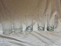 Group shot of two textured low tumblers and three smooth highball glasses