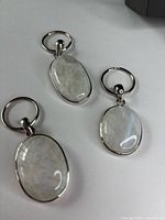 Three oval moonstone keychain pendants on white background